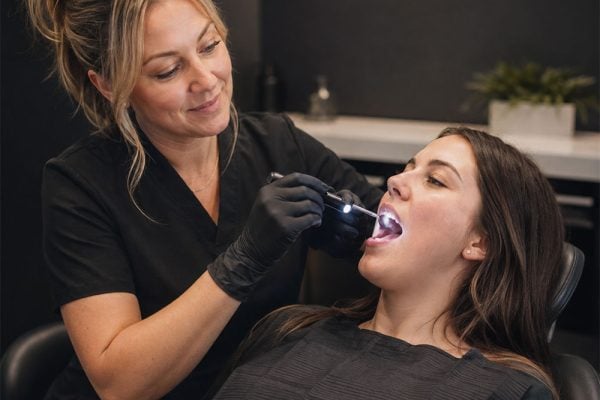 Dentist examining a patient during an oral cancer screening